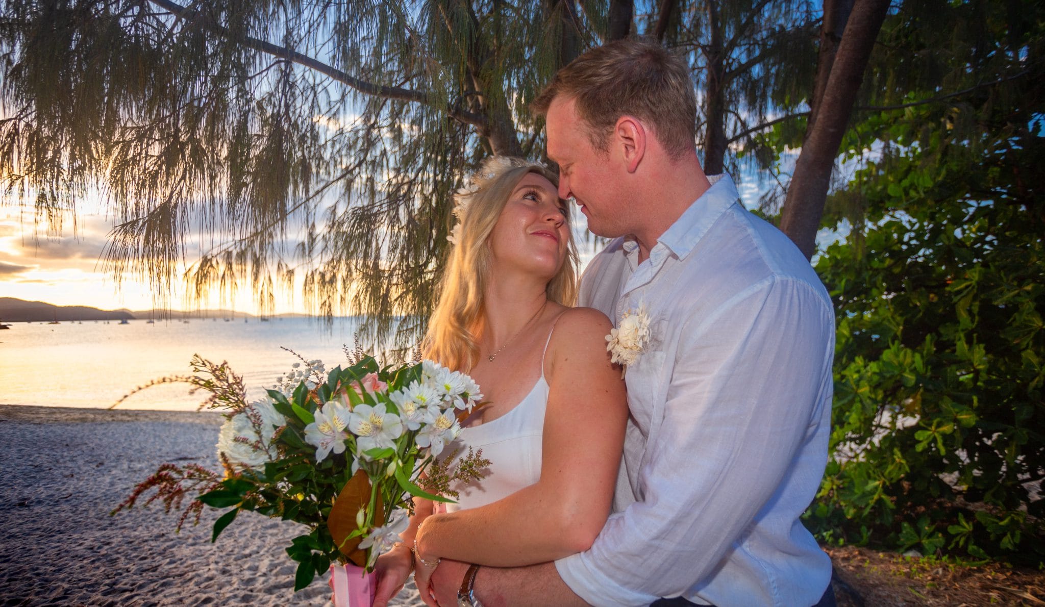Bride and groom looking at each other at sunset