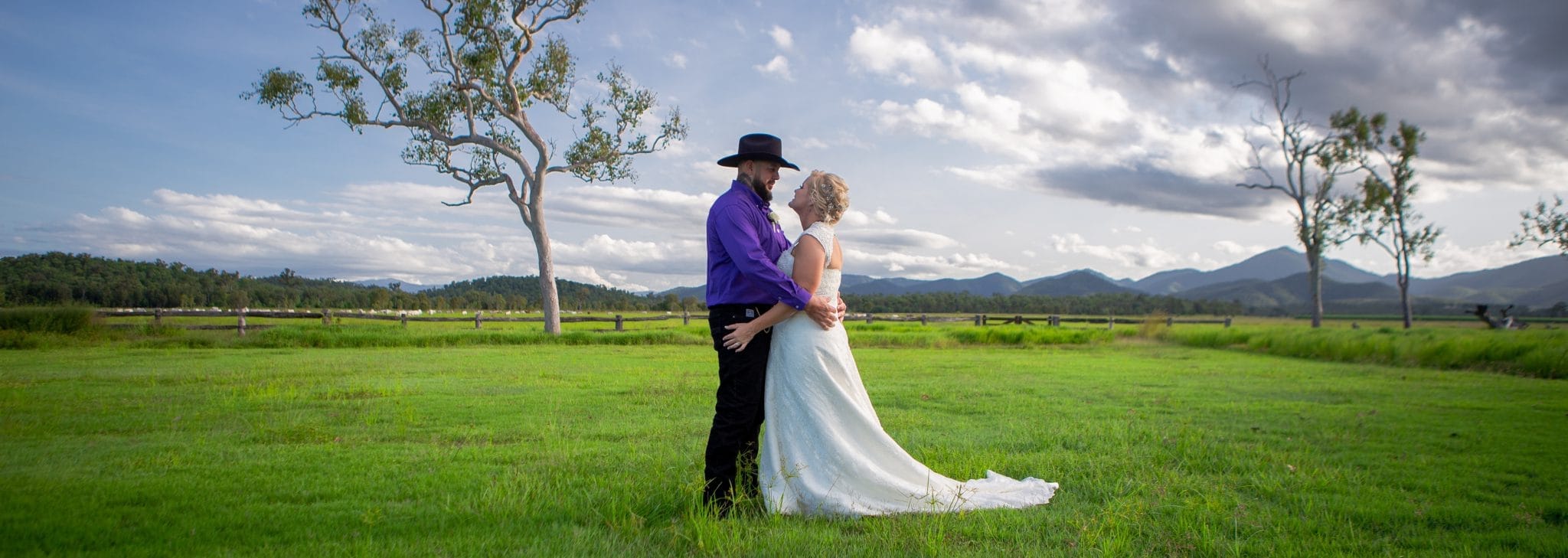 Bride and groom in an embrace on green grass