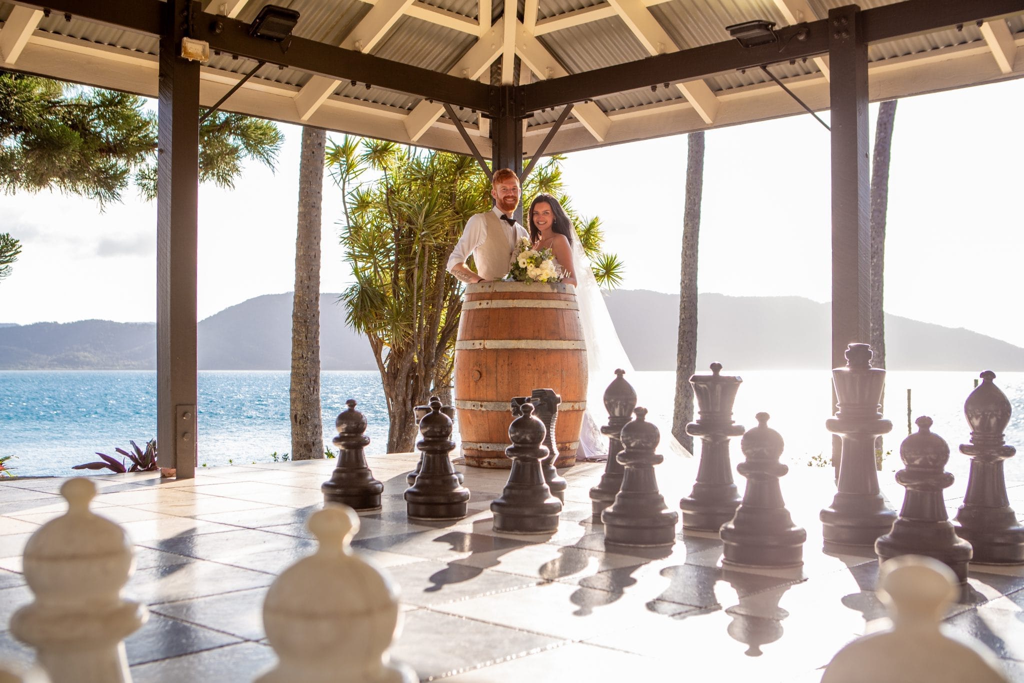 Bride and groom in front of a large chess set